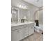 Well-lit bathroom features double vanity sinks, granite countertops, and a shower-tub combo at 15954 Winding Bluff Dr, Montverde, FL 34756