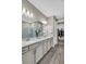 Bathroom showcasing double sinks, granite counters, wood look tile, and a spacious walk-in closet at 15954 Winding Bluff Dr, Montverde, FL 34756