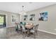 Elegant dining room with a modern chandelier, stylish artwork, and sliding glass doors to the backyard at 15954 Winding Bluff Dr, Montverde, FL 34756