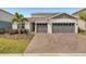 Charming single-Gathering home with a two-car garage, nicely landscaped front yard, and a well-maintained brick driveway at 15954 Winding Bluff Dr, Montverde, FL 34756