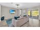 Cozy living room with a plush sofa, a large television, and sliding glass doors leading to the backyard at 15954 Winding Bluff Dr, Montverde, FL 34756