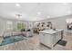 Open-concept living space with modern furnishings, wood-look tile, a center island, and large windows at 15954 Winding Bluff Dr, Montverde, FL 34756