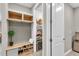 Inviting mudroom with built-in bench, shoe storage, overhead cabinets, and access to a pantry with a wine fridge at 15954 Winding Bluff Dr, Montverde, FL 34756