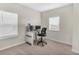 Bright office area with carpet, two windows and a sleek desk setup, creating an ideal workspace at 15954 Winding Bluff Dr, Montverde, FL 34756