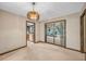 Cozy dining area with an elegant chandelier and sliding glass door to outdoor patio and view into kitchen at 161 Cindy Ct, Lake Mary, FL 32746