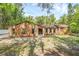 Charming single-story home featuring a unique stone and wood facade, complimented by mature palm trees and a spacious front lawn at 161 Cindy Ct, Lake Mary, FL 32746