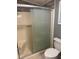 Bathroom features a shower and frosted sliding doors along with a white toilet with a closed lid at 1626 Cypress Pt, Lady Lake, FL 32159