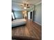 Bedroom with wood floors, ceiling fan, and natural light, with access to the ensuite bathroom at 1626 Cypress Pt, Lady Lake, FL 32159
