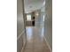 Bright hallway leading to kitchen featuring tiled floors, neutral paint, and modern lighting fixtures at 1626 Cypress Pt, Lady Lake, FL 32159