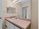 Bathroom featuring a vanity with a pink countertop and a mirrored wall with a light fixture at 1730 Dorset Dr, Mount Dora, FL 32757