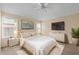 Cozy bedroom featuring a ceiling fan, large television, and stylish furnishings at 1730 Dorset Dr, Mount Dora, FL 32757