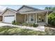 Charming single-story home with a covered front porch, attached garage, and nicely landscaped front yard at 1730 Dorset Dr, Mount Dora, FL 32757