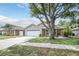 Charming single-story home with attached garage and mature tree in front yard at 1730 Dorset Dr, Mount Dora, FL 32757