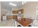 Bright kitchen with wood cabinets, white appliances, granite countertops, tiled flooring, and breakfast nook seating at 1730 Dorset Dr, Mount Dora, FL 32757
