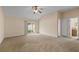 Cozy bedroom featuring carpet, a ceiling fan, patio access, and convenient access to an en-suite bathroom at 1730 Dorset Dr, Mount Dora, FL 32757