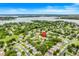 Aerial view of neighborhood homes nestled near a large lake, featuring lush greenery and well-maintained properties at 17428 Woodfair Dr, Clermont, FL 34711