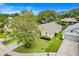 Aerial view showcasing a cozy home with a lush lawn, mature trees, and a peaceful neighborhood setting at 17428 Woodfair Dr, Clermont, FL 34711