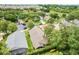 An aerial view showing the property, its well-manicured lawn, and the surrounding neighborhood's lush greenery at 17428 Woodfair Dr, Clermont, FL 34711