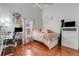 Bright bedroom featuring wood floors, a ceiling fan, and a charming desk area at 17428 Woodfair Dr, Clermont, FL 34711