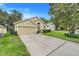 Attractive single-story home with a two-car garage, well-manicured lawn, and a welcoming front entrance at 17428 Woodfair Dr, Clermont, FL 34711