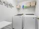 Laundry room with modern washer and dryer units, complemented by practical shelving and storage at 17428 Woodfair Dr, Clermont, FL 34711