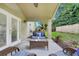 A cozy patio with rattan furniture and a view of the beautiful greenery of the yard at 17428 Woodfair Dr, Clermont, FL 34711