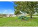Lush, green picnic area with a picnic table under a mature tree offering shade and relaxation at 17428 Woodfair Dr, Clermont, FL 34711