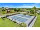 Aerial view of community tennis courts with lighting, landscaping, and easy access to other amenities at 17428 Woodfair Dr, Clermont, FL 34711