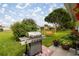 Spacious backyard with a grill and a swing under a large tree at 17533 Se 96Th Ct, Summerfield, FL 34491