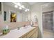 Bright bathroom featuring a large mirror, ample counter space, and a glass-enclosed shower at 17533 Se 96Th Ct, Summerfield, FL 34491