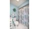 Well-lit blue bathroom with a seashell-themed shower curtain at 17533 Se 96Th Ct, Summerfield, FL 34491