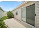 Backyard with a patio, landscaping and a sliding glass door to the interior at 1964 Rhett Rd, The Villages, FL 32163