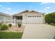 Charming single-story home with a two-car garage, landscaped yard, and a white picket fence at 1964 Rhett Rd, The Villages, FL 32163