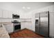 Modern kitchen with stainless steel appliances, white cabinetry, and wood-look flooring at 1964 Rhett Rd, The Villages, FL 32163