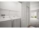 Laundry room with appliances and shelving, next to a doorway to the living room at 1964 Rhett Rd, The Villages, FL 32163