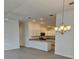 Open-concept living room showcasing the eat-in kitchen, modern lighting, and luxury vinyl floors at 1964 Rhett Rd, The Villages, FL 32163