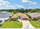 Aerial shot of a well-kept single-story home with manicured lawns, decorative driveway, and colorful landscaping at 219 Carrera Dr, The Villages, FL 32159