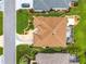 Stunning aerial view of a home with a screened-in pool, beautiful landscaping, and a unique driveway design at 219 Carrera Dr, The Villages, FL 32159