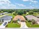 Aerial view of a charming home showcasing meticulous landscaping, unique driveway, and well-maintained surrounding properties at 219 Carrera Dr, The Villages, FL 32159