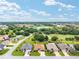 Wide aerial shot exhibiting the residence in a mature and verdant community, highlighting nearby golf courses and community features at 219 Carrera Dr, The Villages, FL 32159
