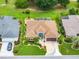Overhead shot reveals a home and its proximity to manicured landscapes, pools, and neighboring residences within the community at 219 Carrera Dr, The Villages, FL 32159