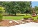 A stunning backyard featuring lush landscaping, mature trees, and a charming water fountain at 219 Carrera Dr, The Villages, FL 32159