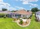 Beautiful backyard featuring a screened-in pool, patio, fountain, and meticulously arranged landscaping at 219 Carrera Dr, The Villages, FL 32159