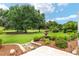 Stunning backyard with mature trees, lush greenery, and a water fountain creating a peaceful retreat at 219 Carrera Dr, The Villages, FL 32159