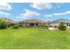 Aerial view of the backyard highlighting the landscaping, mature trees, water feature, and screened lanai at 219 Carrera Dr, The Villages, FL 32159