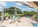 Covered lanai featuring a hot tub, patio seating, and a tranquil view of the landscaped backyard at 219 Carrera Dr, The Villages, FL 32159