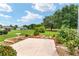 A meticulously landscaped backyard with lush greenery and mature trees creating a private and inviting outdoor oasis at 219 Carrera Dr, The Villages, FL 32159