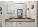 Bathroom featuring a double sink vanity with granite countertops and shared mirror with lighting at 219 Carrera Dr, The Villages, FL 32159