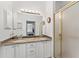 Bathroom featuring a double sink vanity with granite countertops and a shower behind glass at 219 Carrera Dr, The Villages, FL 32159