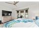 Well-lit bedroom featuring a bay window, ceiling fan, and a TV on a dresser at 219 Carrera Dr, The Villages, FL 32159